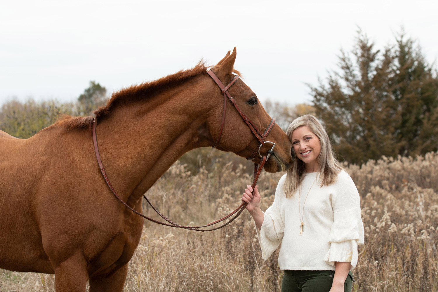 Seventh Farm rider in white sweater with a Thoroughbred horse